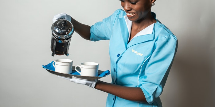 Assistente de bordo fazendo um café